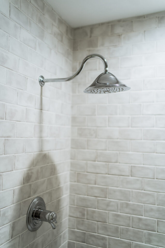 Gray subway tile in a brick pattern with white grout for a spa-like walk-in shower | Adored by Alex